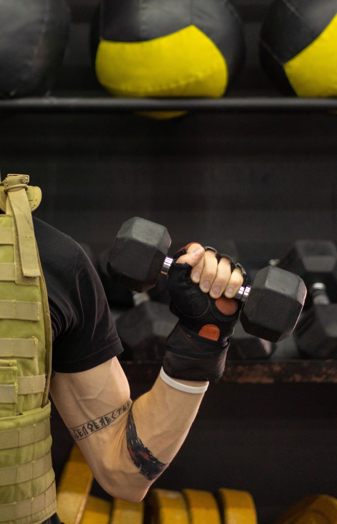 Athlete in a weighted vest training with a dumbbell